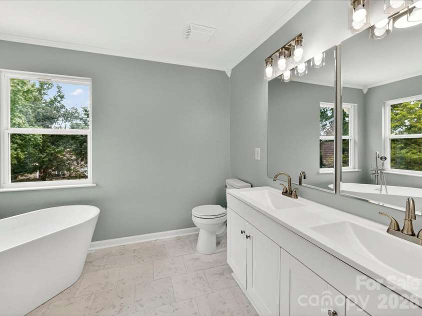 9716 Pernell Lane, Charlotte, NC 28213.  MLS# CAR4383771, YatesRealty ID 29190. Luxurious primary bath features a dual vanity, elegant freestanding soaking tub, separate shower, and bright spa-like finishes designed for relaxation and comfort.