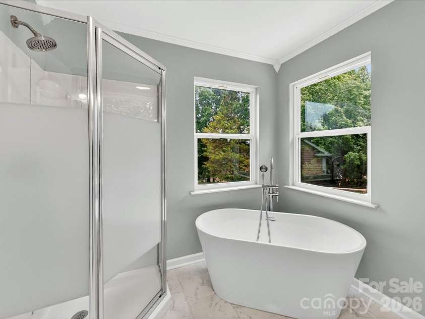 9716 Pernell Lane, Charlotte, NC 28213.  MLS# CAR4383771, YatesRealty ID 29190. Luxurious primary bath features a dual vanity, elegant freestanding soaking tub, separate shower, and bright spa-like finishes designed for relaxation and comfort.