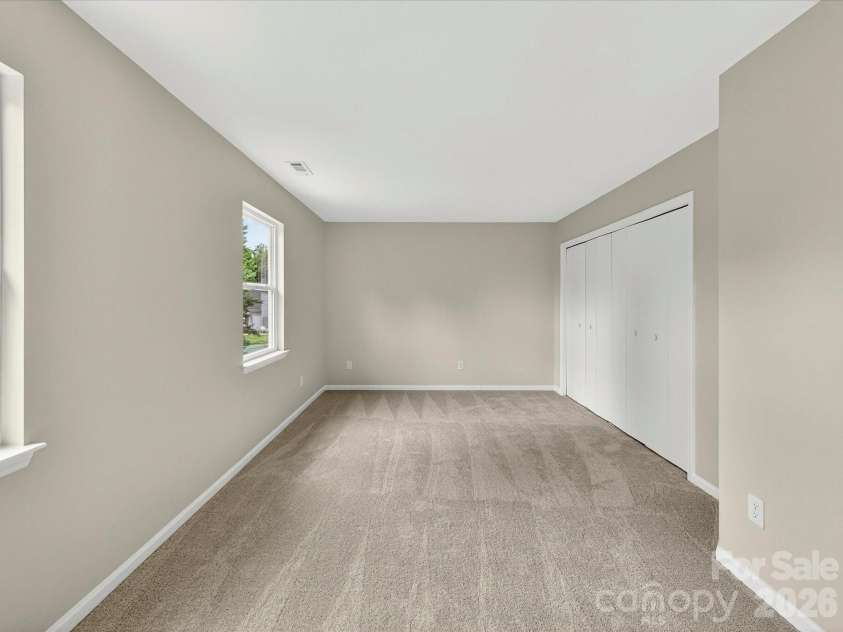 9716 Pernell Lane, Charlotte, NC 28213.  MLS# CAR4383771, YatesRealty ID 29190. Spacious secondary bedroom offers plush carpeting, abundant natural light, and a versatile layout perfect for guests, family, or a home office.