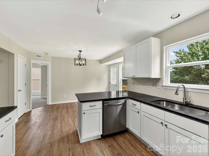 9716 Pernell Lane, Charlotte, NC 28213.  MLS# CAR4383771, YatesRealty ID 29190. Updated kitchen showcases sleek granite countertops, stainless steel appliances, modern white cabinetry, and a functional layout designed for both everyday living and entertaining.