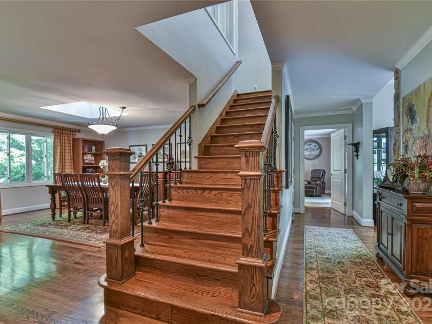 409 North Fork Road, Black Mountain, NC 28711.  MLS# CAR4284708, YatesRealty ID 29252. From the entrance hall, wide hallways provide easy access to the powder bath, upstairs, downstairs, kitchen, main level living room, or main level en suite bedroom.