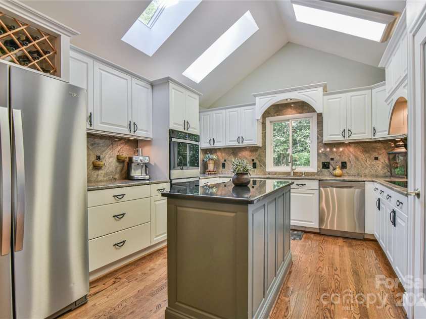 409 North Fork Road, Black Mountain, NC 28711.  MLS# CAR4284708, YatesRealty ID 29252. Prep space and excellent work flow is convenient with the custom island, and seating is available at the peninsula bar. 