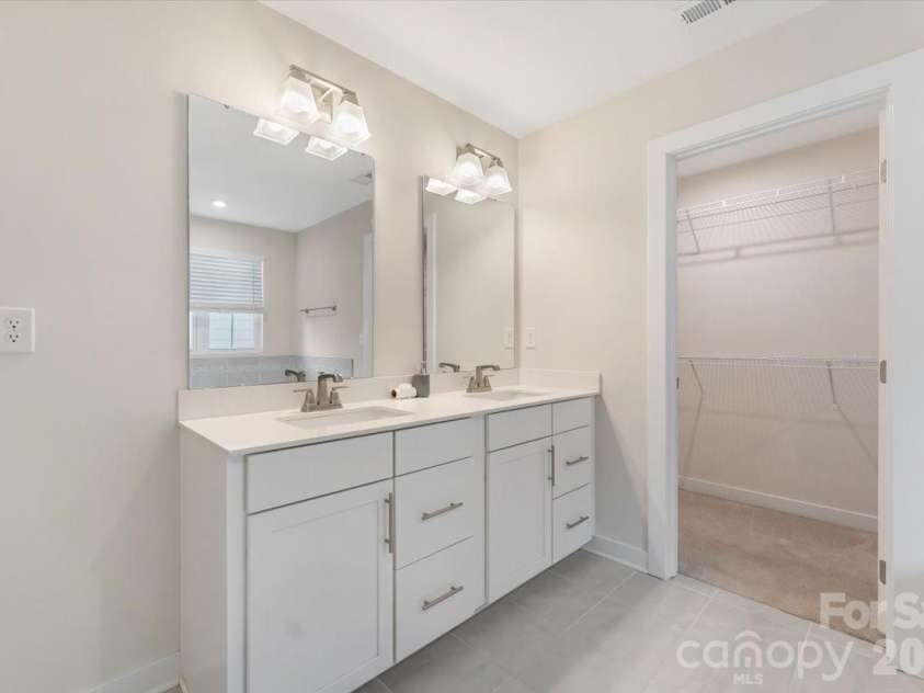 202 Tetcott Street, Mooresville, NC 28115.  MLS# CAR4364351, YatesRealty ID 29274. Primary bath's dual vanity flows effortlessly into the large walk-in closet, blending function and everyday luxury