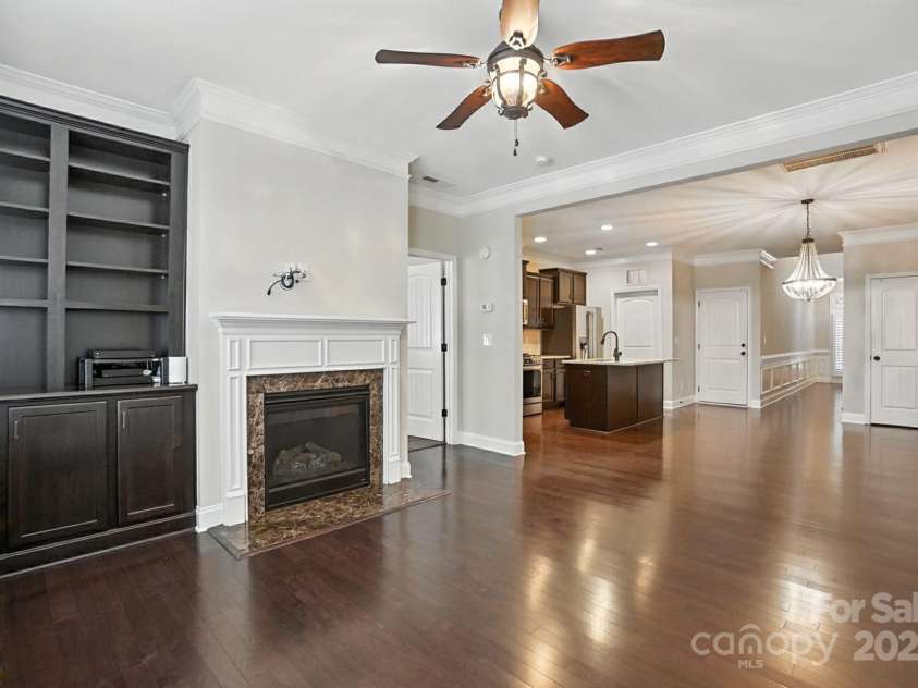 4128 La Crema Drive, Charlotte, NC 28214.  MLS# CAR4284944, YatesRealty ID 29298. The lake-facing Great Room is designed for comfort and elegance, boasting a cozy fireplace and custom built-in cabinetry, creating an ideal space for relaxation and entertaining