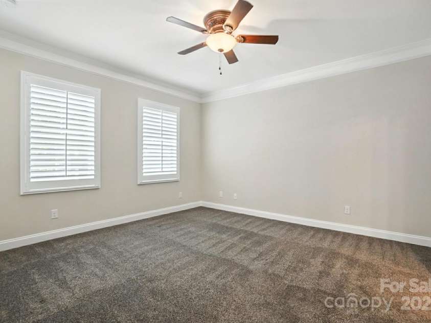 4128 La Crema Drive, Charlotte, NC 28214.  MLS# CAR4284944, YatesRealty ID 29298. The luxurious Primary Suite, conveniently located on the main level, offers a serene escape with its spa-like bath and direct, beautiful lake views to wake up to