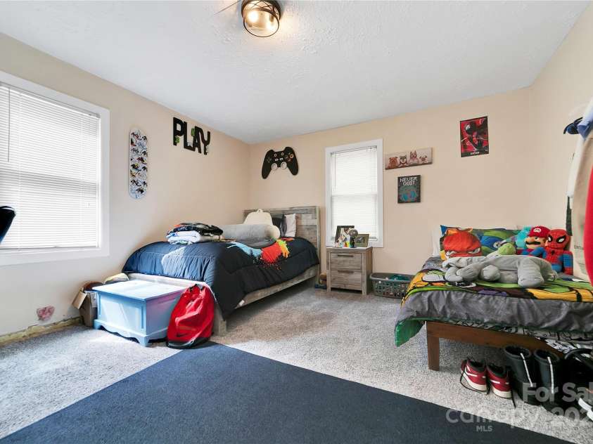 89 Whitmire Street, Brevard, NC 28712.  MLS# CAR4281325, YatesRealty ID 29327. Big, bright, and full of natural light this second bedroom’s got plenty of space to make it your own, whether that’s a comfy guest room, home office, or just a chill spot to relax.