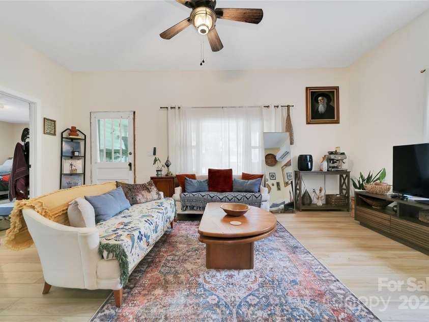 89 Whitmire Street, Brevard, NC 28712.  MLS# CAR4281325, YatesRealty ID 29327. Bright and airy with plenty of natural light, this living room feels even more open thanks to the raised ceilings a thoughtful update by the current owner that really adds to the home's charm and spaciousness.