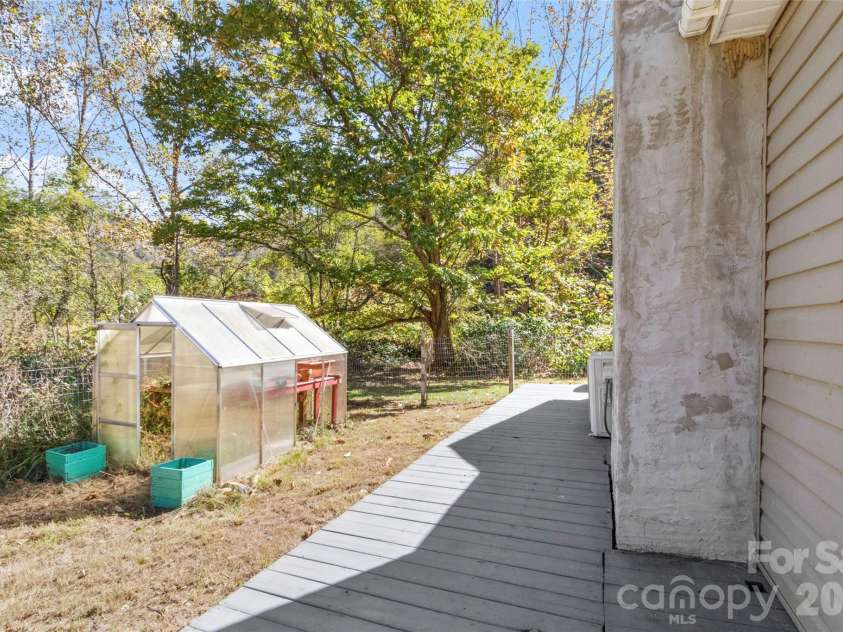 689 Bald Mountain Road, Burnsville, NC 28714.  MLS# CAR4309436, YatesRealty ID 2933. Side yard with Greenhouse
