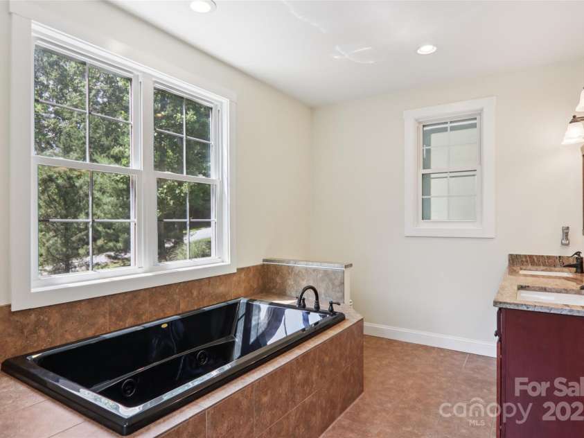 398 Falling Leaves Lane, Hendersonville, NC 28792.  MLS# CAR4267350, YatesRealty ID 29335. Primary bathroom with double sink & jacuzzi tub