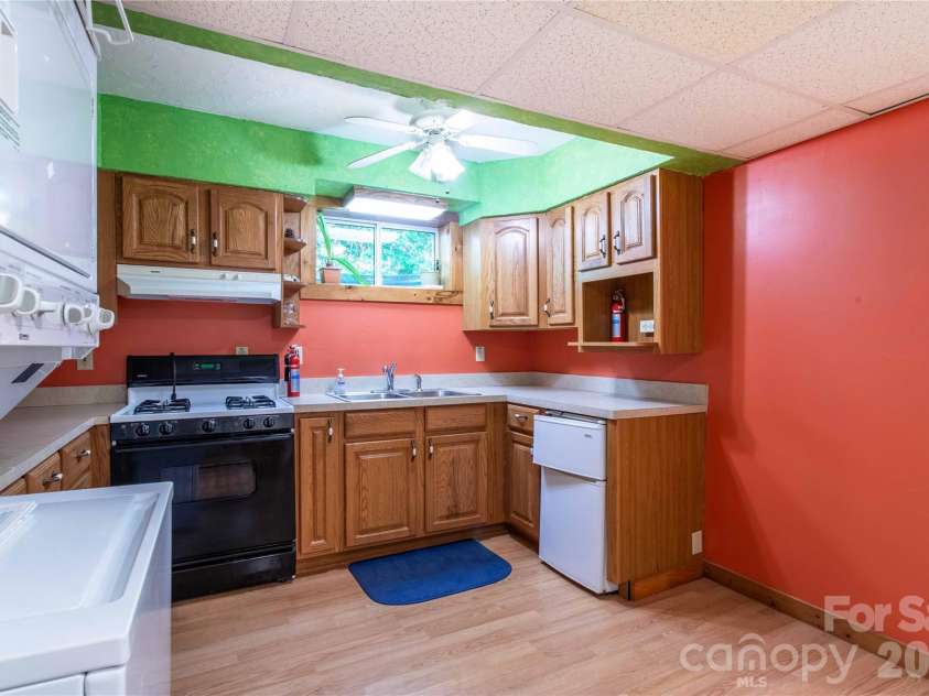 22 Great Aspen Way, Black Mountain, NC 28711.  MLS# CAR4388934, YatesRealty ID 29345. Lower level kitchenette features never used stacked washer and dryer. There is also space for a snack bar on the right.