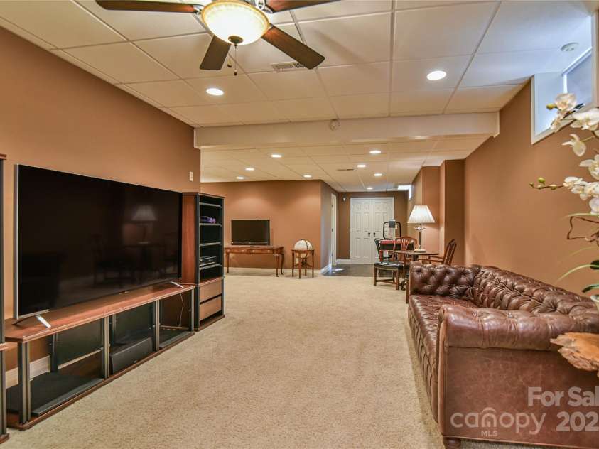 110 Michael Court, Leicester, NC 28748.  MLS# CAR4283846, YatesRealty ID 29373. Large lower level entertaining area or could be a living room for a future airbnb, in-law or visitors on college break. With a gas fireplace.