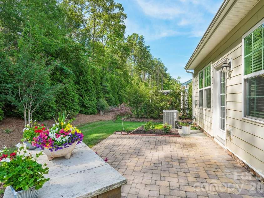 128 Van Gogh Trail, Mount Holly, NC 28120.  MLS# CAR4387655, YatesRealty ID 29376. Sweet paver patio with a raised garden wall and lots of trees