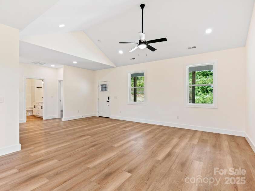 169 Vineyard Village Drive, Old Fort, NC 28762.  MLS# CAR4268925, YatesRealty ID 29376. Off the living room is a hall with 2 guest bedrooms, laundry room & primary w/ on suite.  All on one level. 