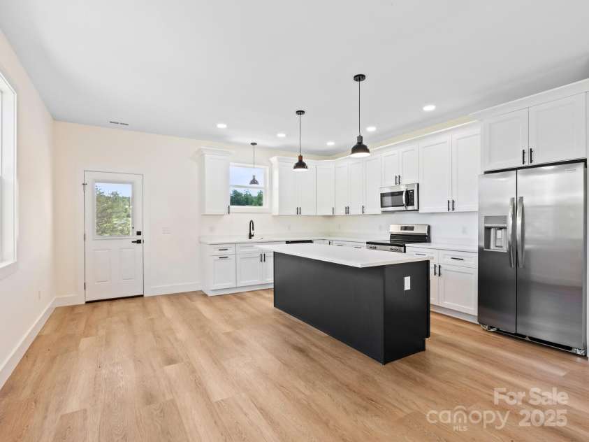 169 Vineyard Village Drive, Old Fort, NC 28762.  MLS# CAR4268925, YatesRealty ID 29376. The bright kitchen sits at the back of the home with a door opening onto the large deck.  Convenient for grilling or dinning al fresco as you look out at the view. 