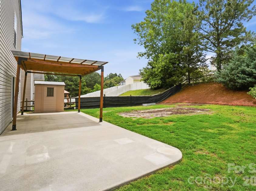768 Bartram Avenue, Concord, NC 28025.  MLS# CAR4385709, YatesRealty ID 29377. Expansive backyard patio with a structure to allow a shaded space for dining or relaxing and still more room for fun!