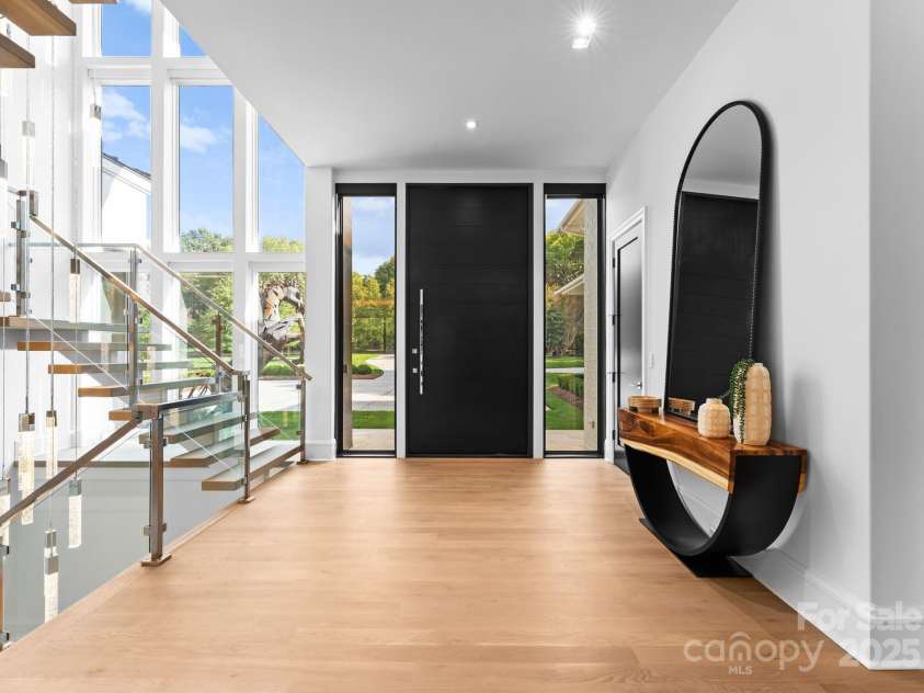 2116 Woodhaven Road, Charlotte, NC 28211.  MLS# CAR4186147, YatesRealty ID 2938. Entryway with floating staircase and a 10 ft. tall and 5 ft. wide mahogany picot custom front door