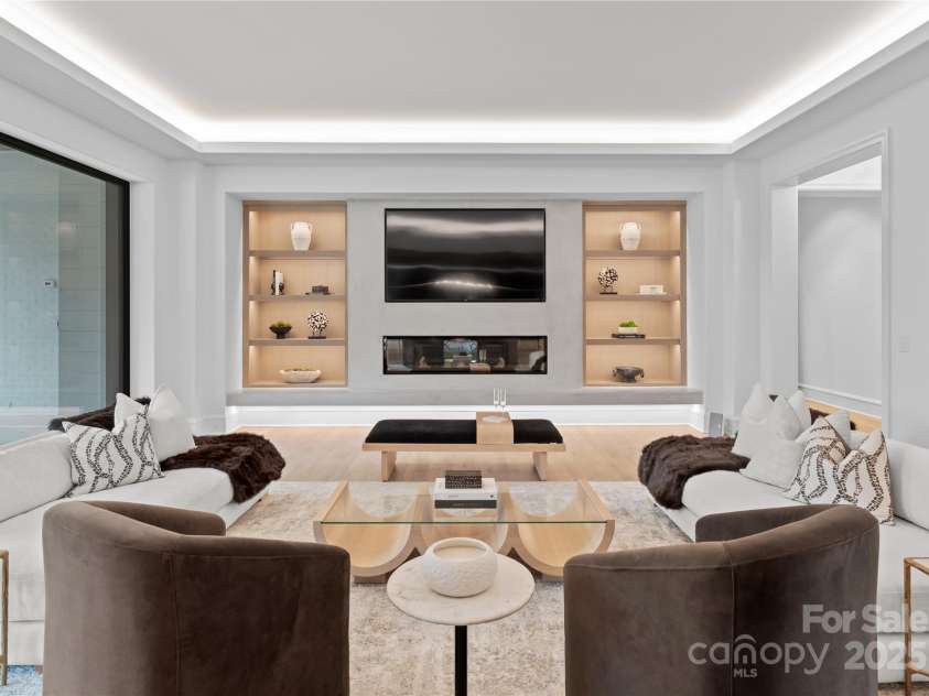 2116 Woodhaven Road, Charlotte, NC 28211.  MLS# CAR4186147, YatesRealty ID 2938. Great Room opening to outdoor covered and patio and built-in grilling area. Accented with custom built-in's and linear fireplace with elegant plastered surround
