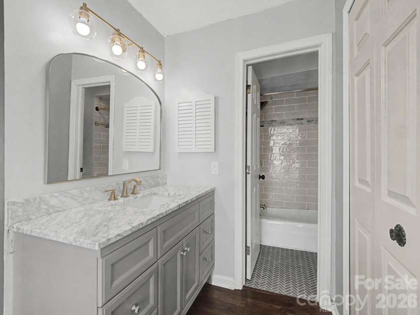 1409 Kensington Road, Hendersonville, NC 28791.  MLS# CAR4345772, YatesRealty ID 2946. Primary en suite bathroom vanity area and full private bath featuring gorgeous tile work. 