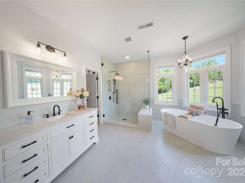 4660 Sugar Plum Lane, Davidson, NC 28036.  MLS# CAR4273062, YatesRealty ID 29516. Primary Suite Bathroom (updated 2023) w/frameless shower w/bench & rain head, free standing tub and 2 vanities w/quartz countertops.