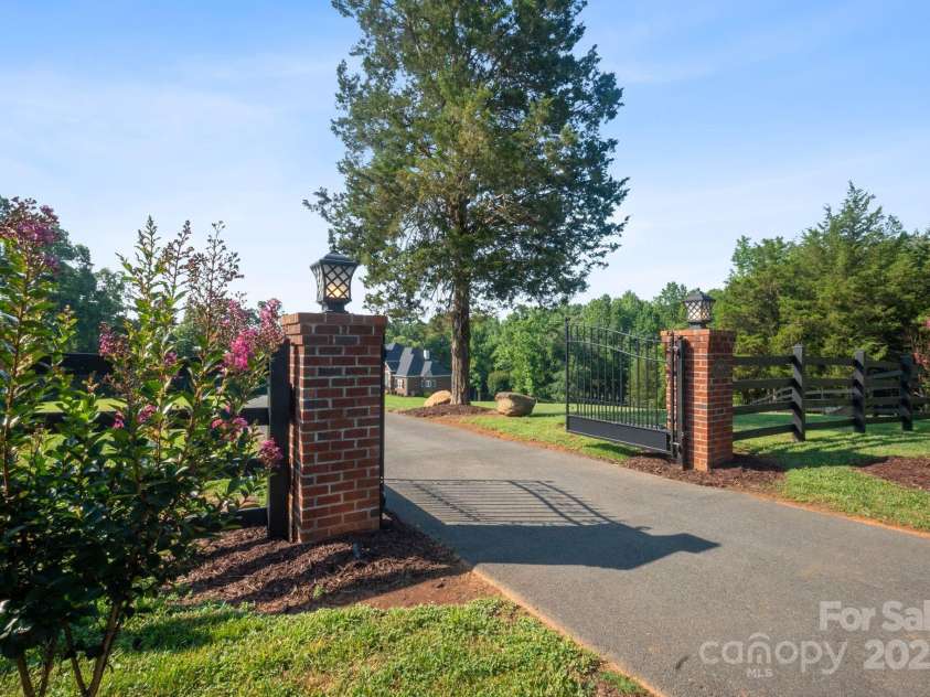 4660 Sugar Plum Lane, Davidson, NC 28036.  MLS# CAR4273062, YatesRealty ID 29516. Private, secure. Brick columns w/lights, keypad, new black board fencing.