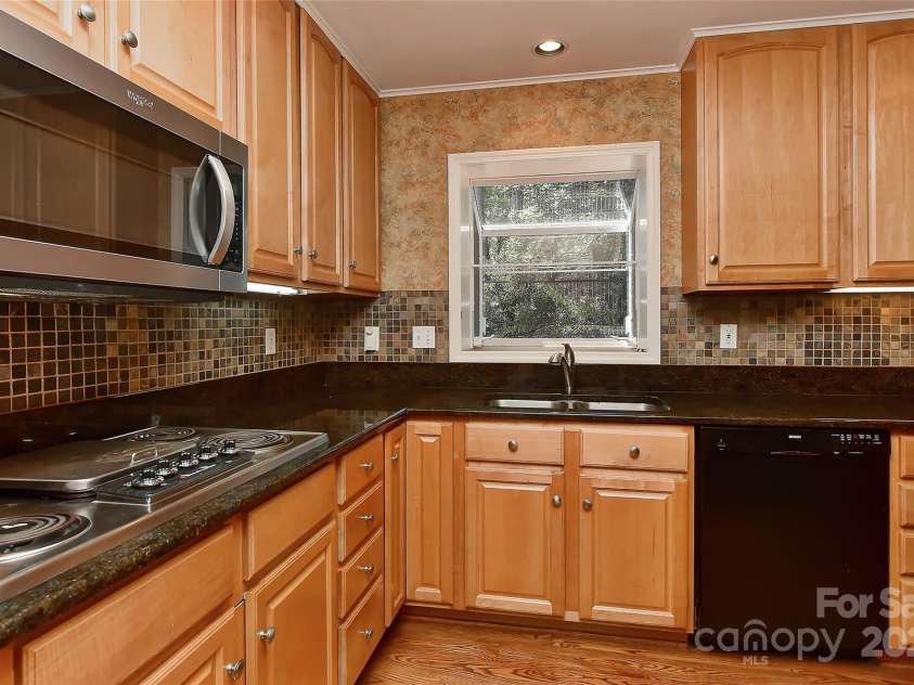 6117 Yellowood Road, Charlotte, NC 28210.  MLS# CAR4272398, YatesRealty ID 29599. Granite counter tops, tile back splash, dual SS sink with window box and Bosch dishwasher.