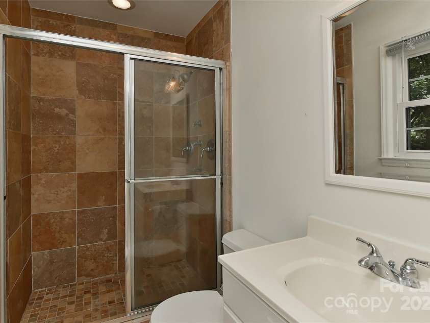 6117 Yellowood Road, Charlotte, NC 28210.  MLS# CAR4272398, YatesRealty ID 29599. Primary full bath with tile surround in shower, body sprayer plus shower head, tile flooring, light on a dimmer, slow close toilet lid