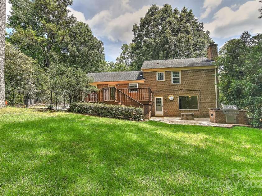 6117 Yellowood Road, Charlotte, NC 28210.  MLS# CAR4272398, YatesRealty ID 29599. Rear of all brick home with large deck & patio. The patio features built in gas grill w/gas line and also a firepit. The rear yard is fenced.