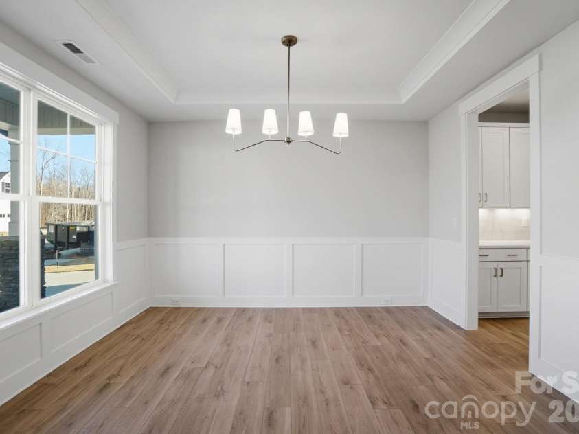 5054 McLaughlin Loop, Waxhaw, NC 28173.  MLS# CAR4329156, YatesRealty ID 29609. Dining room with Craftsman-style trim and tray ceiling