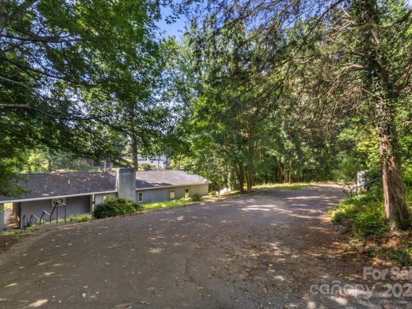 7645 Buckland Road, Charlotte, NC 28278.  MLS# CAR4275011, YatesRealty ID 29621. Driveway is elevated from the main level. Hypothetically a buyer could add a second level to the house and have it level with the driveway. The second level would have lake views from both sides!