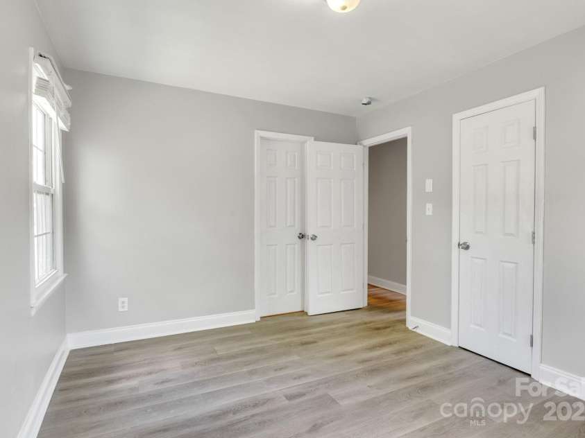 609 Bilmark Avenue, Charlotte, NC 28213.  MLS# CAR4276678, YatesRealty ID 29671. Second shot of primary bedroom, facing open entry door. Closed door in the center leads to a powder room & en-suite full bathroom.