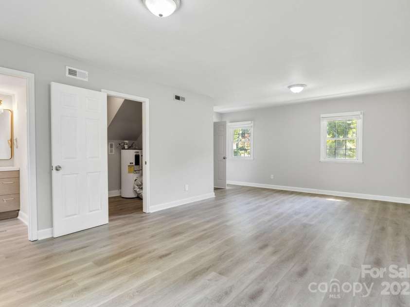 609 Bilmark Avenue, Charlotte, NC 28213.  MLS# CAR4276678, YatesRealty ID 29671. Second shot of the lower-level bonus room with back against the glass door that opens to the backyard. Open entry on left leads to a half bath; open door towards the center leads to connected laundry room.