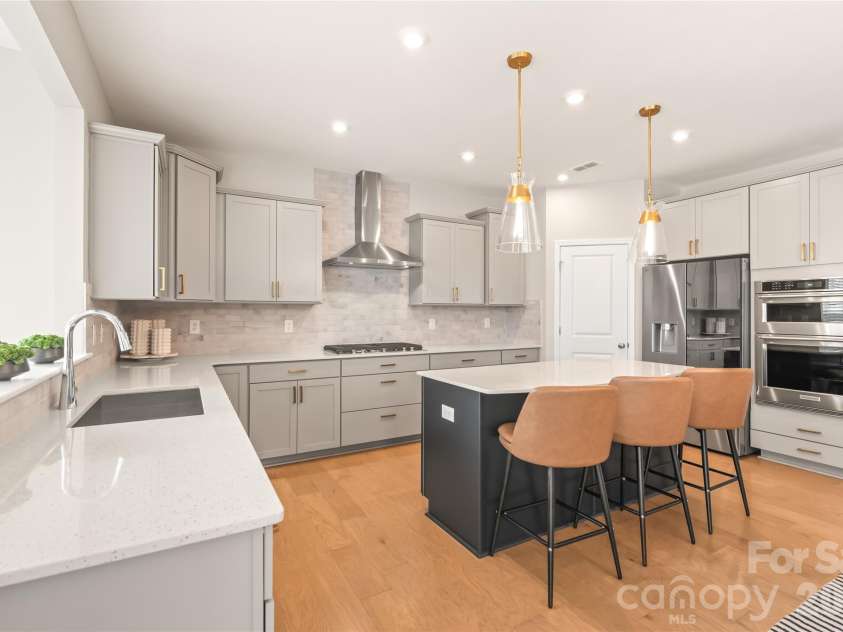 12205 Hollinhope Drive, Charlotte, NC 28278.  MLS# CAR4385321, YatesRealty ID 29673. A Dream Kitchen! Kitchen island with seating, Quartz counters, Stainless Steel appliances including gas cooktop, wall oven, exhaust hood, and pantry