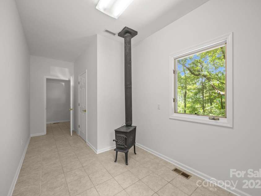110 Thrashing Rock Drive, Hendersonville, NC 28739.  MLS# CAR4282429, YatesRealty ID 29693. Mudroom off garage area with wood heater