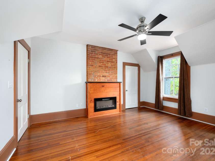 11 Cullowhee Street, Asheville, NC 28801.  MLS# CAR4307173, YatesRealty ID 297. Electric Fireplace with Decorative Brick and Wood Surround 