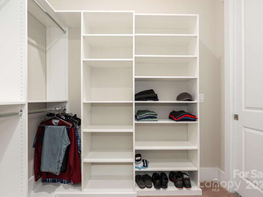 21016 Molly Harper Drive, Cornelius, NC 28031.  MLS# CAR4320388, YatesRealty ID 29705. Another custom closet in the primary with easy access through a pocket door to the laundry - even the door detail was considered to maximize the functional closet space! 