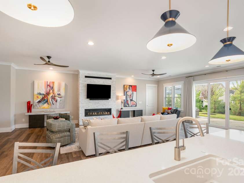 21016 Molly Harper Drive, Cornelius, NC 28031.  MLS# CAR4320388, YatesRealty ID 29705. The kitchen overlooks a fabulous great room with a stone fireplace surround highlighting the linear fireplace. Large windows and doors create a fantastic flow to the oversized outdoor patio. This is an incredible 