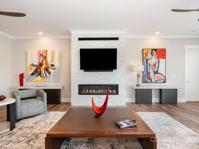 21016 Molly Harper Drive, Cornelius, NC 28031.  MLS# CAR4320388, YatesRealty ID 29705. Warmth from the linear fireplace and lighting to highlight your own art selection