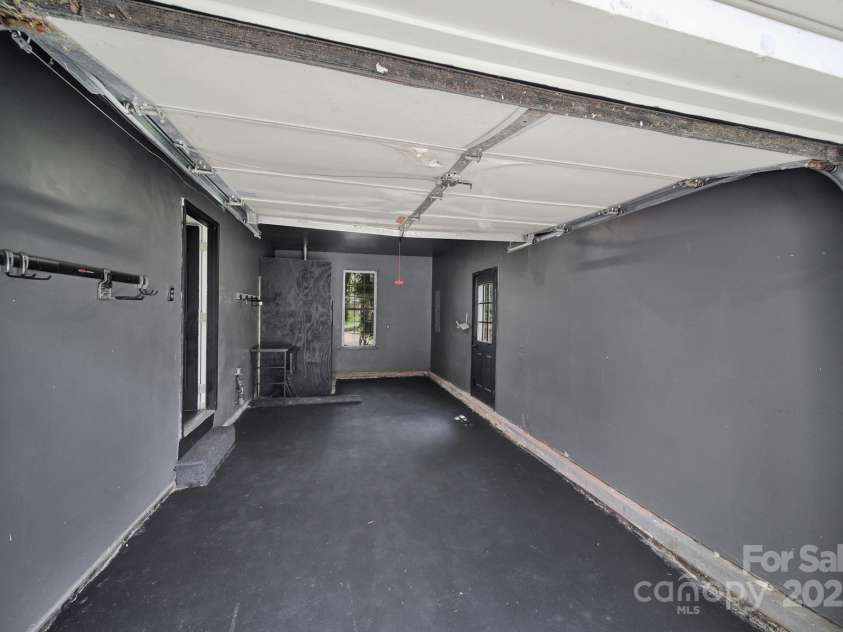 7801 Bella Vista Court, Charlotte, NC 28216.  MLS# CAR4285247, YatesRealty ID 29767. 1 car garage is oversized and has freshly painted floor, finished walls, storage area, and side door access to yard.
