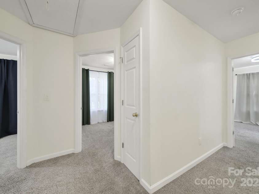 7801 Bella Vista Court, Charlotte, NC 28216.  MLS# CAR4285247, YatesRealty ID 29767. Hall view shows entrances to other bedrooms and neutral paint.