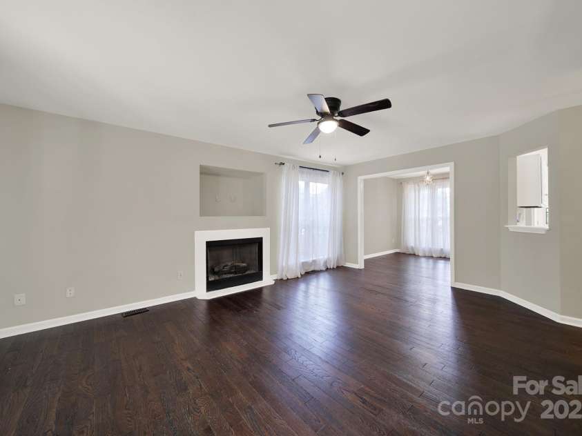 7801 Bella Vista Court, Charlotte, NC 28216.  MLS# CAR4285247, YatesRealty ID 29767. Large Family Room has TV nook and gas logs fireplace, ceiling fan and hardwood floors.