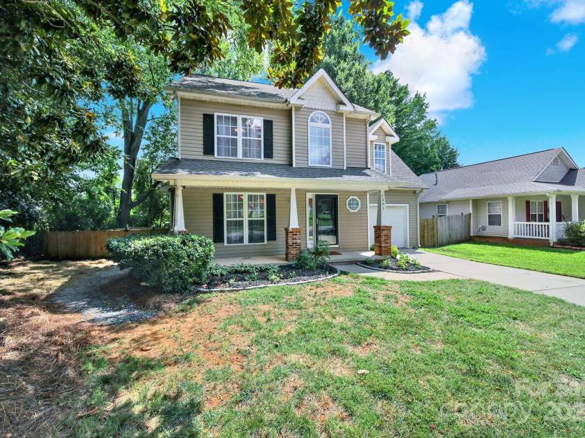 7801 Bella Vista Court, Charlotte, NC 28216.  MLS# CAR4285247, YatesRealty ID 29767. Side view showing yard, driveway, porch and landscaping.