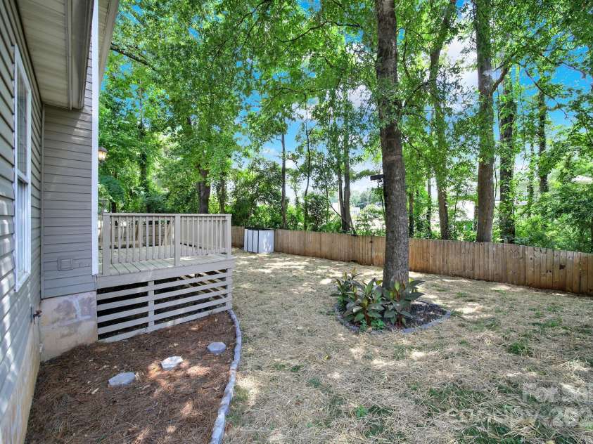 7801 Bella Vista Court, Charlotte, NC 28216.  MLS# CAR4285247, YatesRealty ID 29767. View from the back side of the home showing the NEW deck, freshly seeded yard, fence, and mature landscaping.