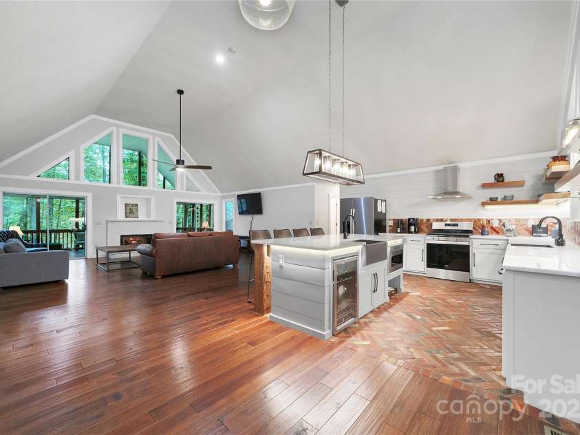 557 Country Club Estates Drive, Sapphire, NC 28774.  MLS# CAR4302980, YatesRealty ID 2977. Coming in the front door you enter this huge great room that goes from front to back of the house. Lots of natural light throughout with big window walls on both sides!