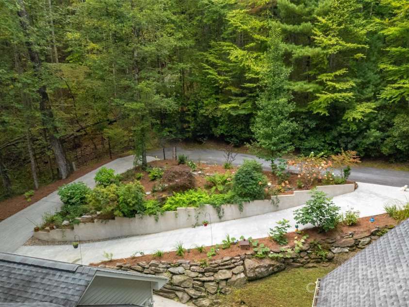 557 Country Club Estates Drive, Sapphire, NC 28774.  MLS# CAR4302980, YatesRealty ID 2977. Cul-de-sac and circular driveways seen from above the house. Great landscaping in front, great trees across the road, wonderful privacy all around.