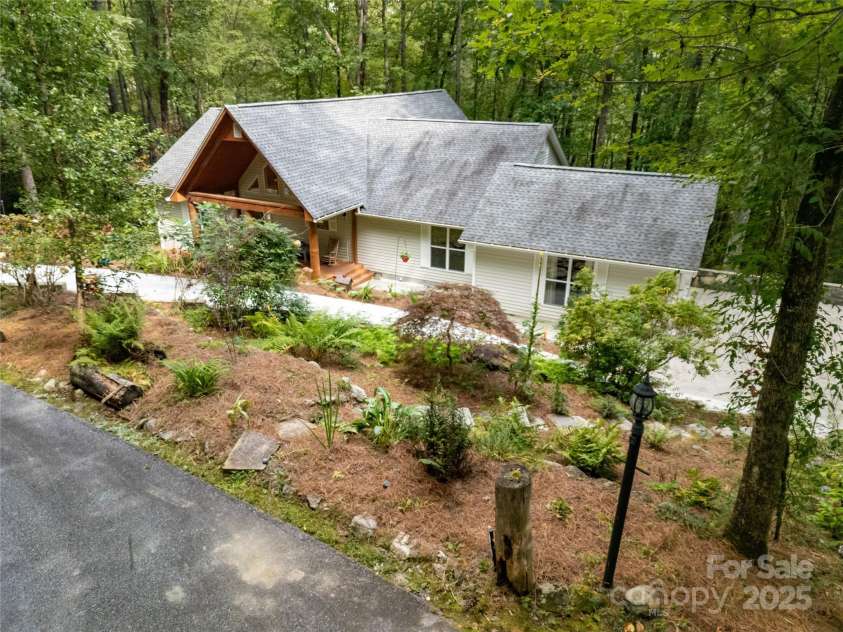 557 Country Club Estates Drive, Sapphire, NC 28774.  MLS# CAR4302980, YatesRealty ID 2977. House from the culdesac. Great landscaping in front, great trees in back, wonderful privacy all around.