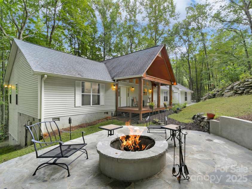 557 Country Club Estates Drive, Sapphire, NC 28774.  MLS# CAR4302980, YatesRealty ID 2977. House Front as seen from the Firepit Area. Tall mature trees create the back and side yards, with a spring running on one side.
