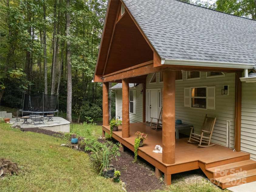 557 Country Club Estates Drive, Sapphire, NC 28774.  MLS# CAR4302980, YatesRealty ID 2977. House Front Porch and Firepit area as seen from the bottom of driveway. Little 'Macie' watches all arrivals!