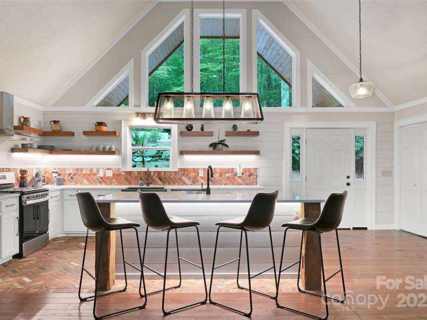 557 Country Club Estates Drive, Sapphire, NC 28774.  MLS# CAR4302980, YatesRealty ID 2977. Large windows above the kitchen allow plenty of natural brightness within to cook and converse.