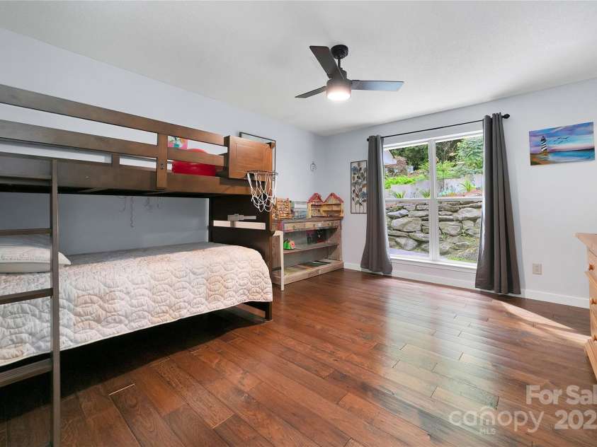 557 Country Club Estates Drive, Sapphire, NC 28774.  MLS# CAR4302980, YatesRealty ID 2977. On the other side of the great room are the other two bedrooms. Large window with landscaping outside in this front room.  