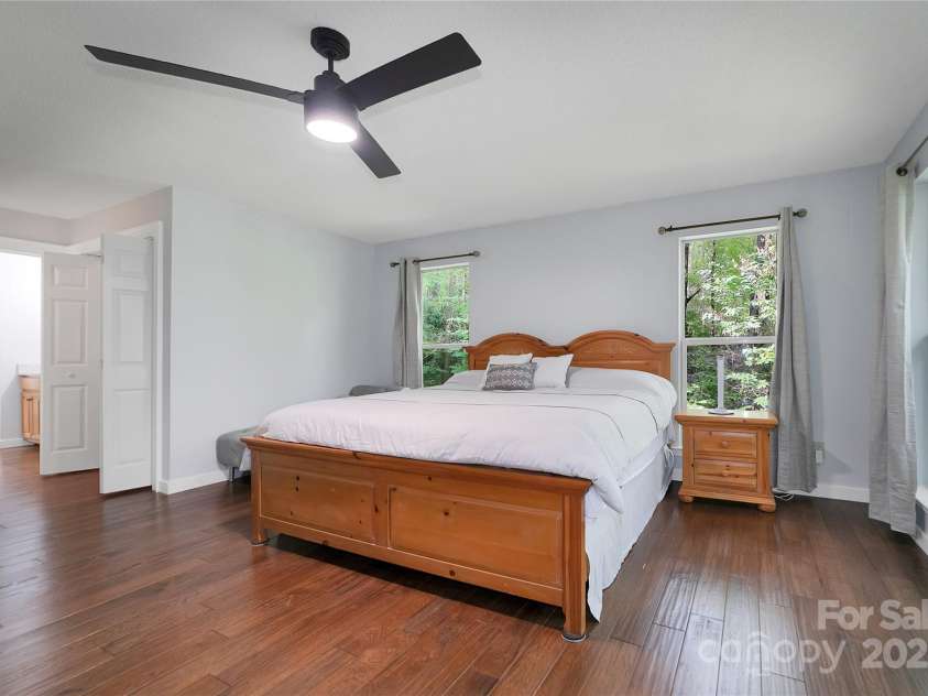 557 Country Club Estates Drive, Sapphire, NC 28774.  MLS# CAR4302980, YatesRealty ID 2977. Primary bedroom has plenty of space and boasts the beautiful wood floors. Very private.